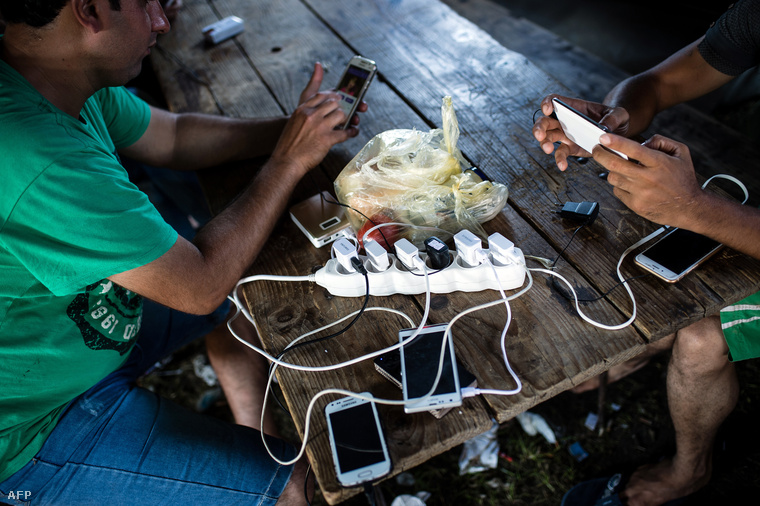 Menekültek töltik telefonjaikat a szerbiai Kanjizában