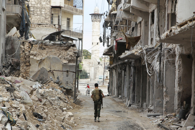 A Szír Szabadhadsereg katonája cipeli fegyverét Aleppó romjainál, 2015. augusztus 30-án.