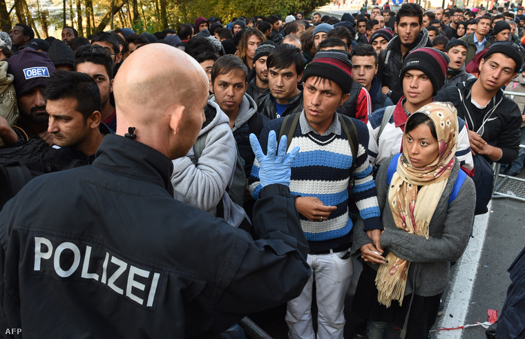 Német rendőr beszél a menekültekkel, az osztrák-német határon, Passau közelében, 2015. október 28-án.