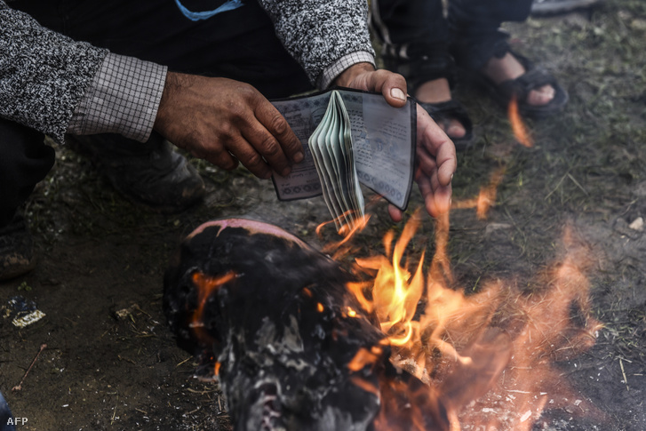 A papírjait szárítja egy menekült a tűz mellett Görögországban
