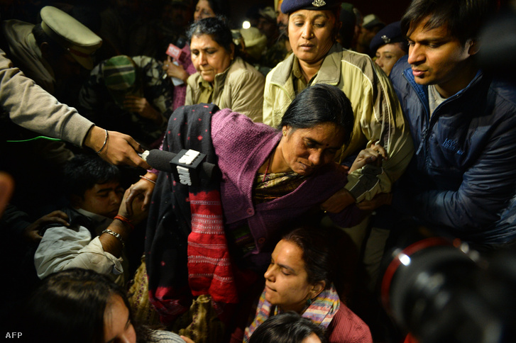 Tüntetők védik a 2012-ben meghalt lány édesanyját, akit rendőrök próbálnak elvinni az erőszak miatt elítélt fiú szabadon engedése ellen szervezett demonstráción, Új-Delhiben, december 20-án.