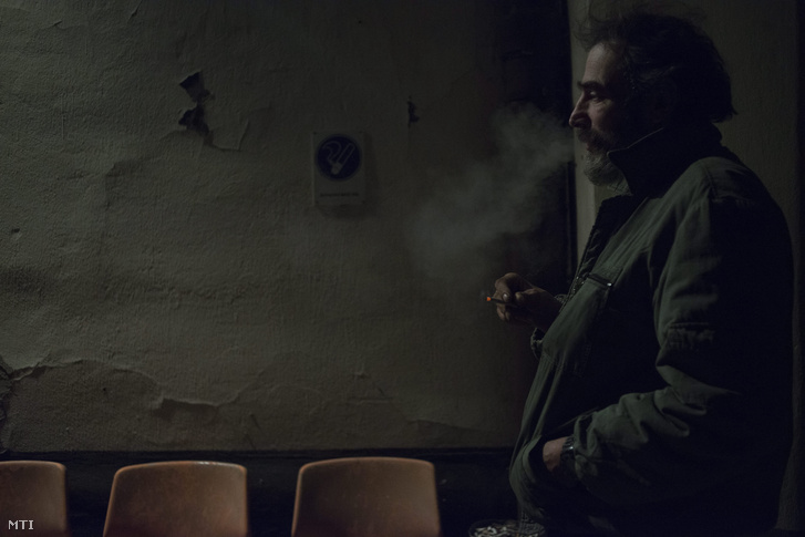 Hajléktalan férfi dohányzik a Magyar Máltai Szeretetszolgálat Rimaszombati úti krízisszállója előtt 2014. december 30-án este.