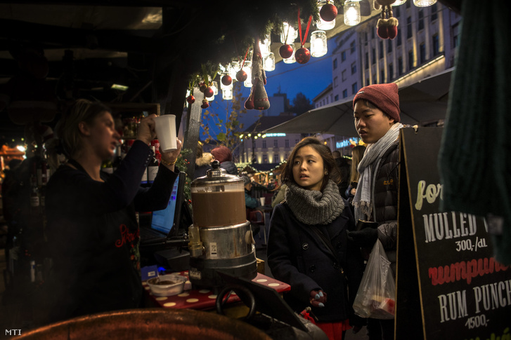 Külföldi turisták Budapesten a Vörösmarty téri karácsonyi vásárban 2015. december 25-én.