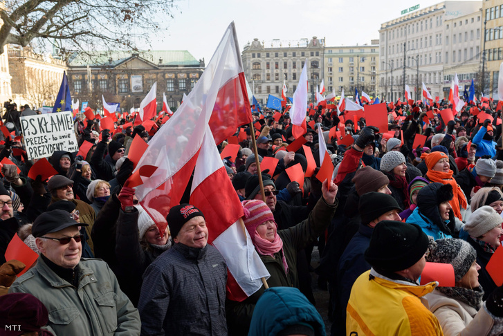 Demokráciát követelő kormányellenes tüntetők piros lappal a kezükben tiltakoznak a novemberi lengyel parlamenti választásokon győztes Jog és Igazságosság (PiS) párt ellen Poznanban 2016. január 2-án.