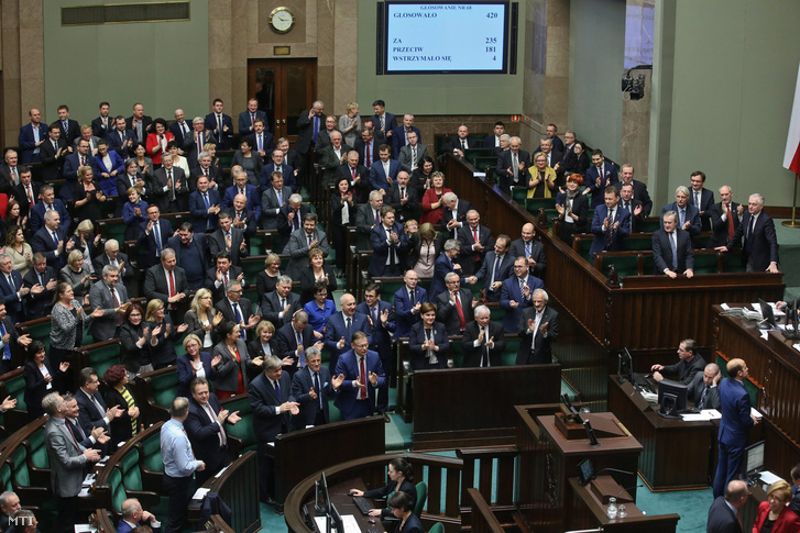 A kormányzó a Jog és Igazságosság (PiS) párt képviselői tapsolnak miután a lengyel parlament alsóháza a szejm megszavazta az alkotmánybíróságról szóló törvény módosítását