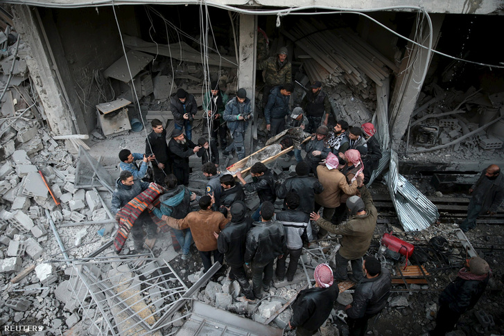 Holttestet emelnek ki a romok közül egy orosz légicsapás után január 10-én, Douma belvárosában.