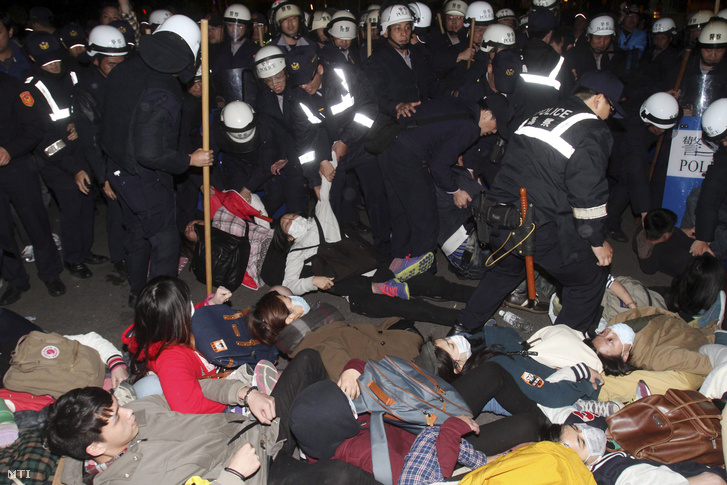 Tajvan és Kína közötti kereskedelmi egyezmény ellen tiltakozó tüntetőket távolítanak el rendőrök egy tajpeji kormányhivatalból 2014. március 24-én.
