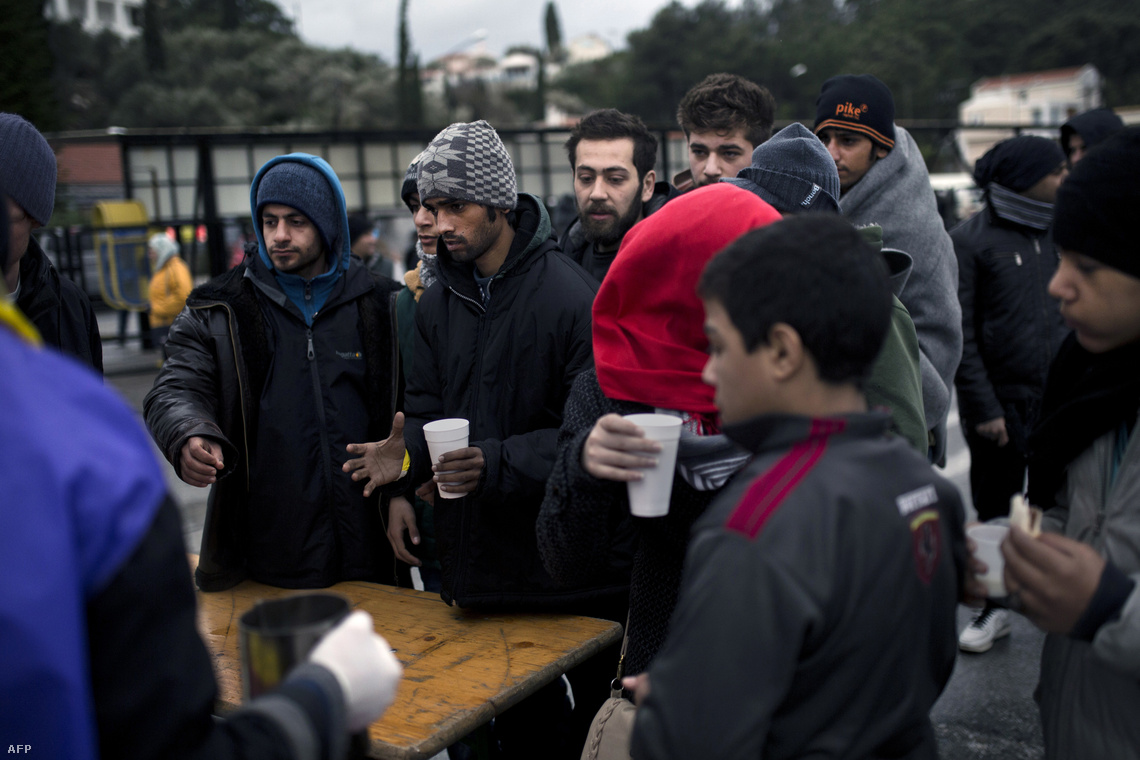 Menekültek melegednek egy pohár tea mellett a regisztrációs ponton a görög Szamosz-szigeten