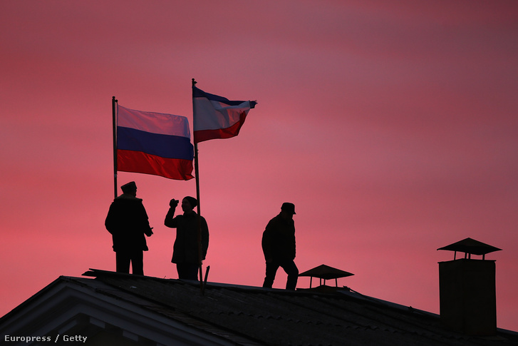 Orosz katonák helyezik ki az orosz zászlót egy krími városházra.