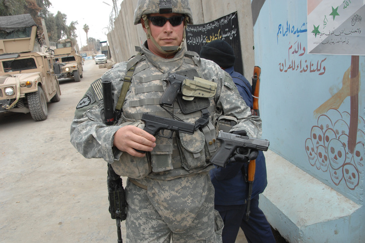 Egy valódi 9mm-es és egy játékpisztolyt tart a kezében egy amerikai katona Irakban