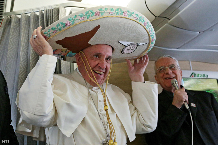 Ferenc pápa egy újságírótól ajándékba kapott mexikói sombrerót visel a Rómából Havannába tartó repülőgép fedélzetén.