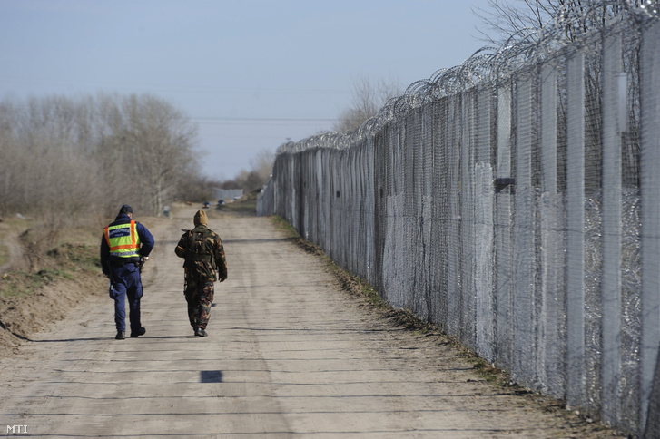 Magyar rendőr és katona sétál a szerb határ mellett felhúzott kerítés mentén