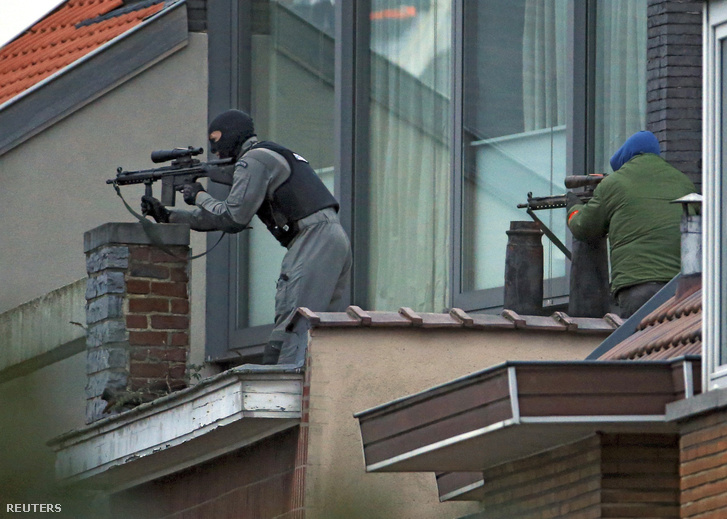 Belga rendőrök egy közeli háztetőről biztosítják a terepet.