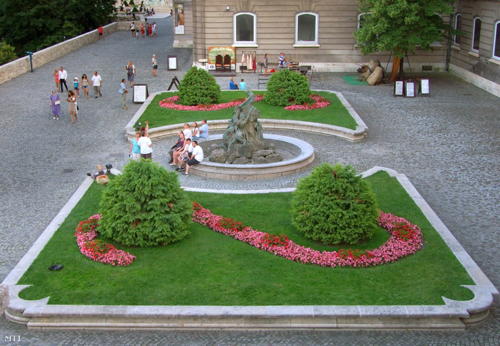 Turisták a Budavári Palotában a Nemzeti Galéria díszkertjében a Halászó fiú szökőkútjánál.