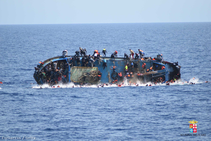 Az olasz haditengerészet által közreadott felvételen menekültek ugrálnak a tengerbe egy süllyedő hajó fedélzetéről Líbia partjainál 2016. május 25-én.