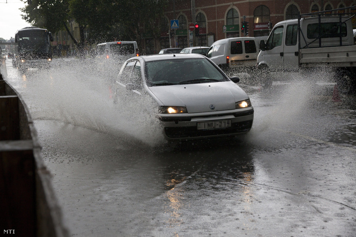 Felhõszakadás után autó halad a vízzel elárasztott utcán Kaposváron 2016. június 13-án.