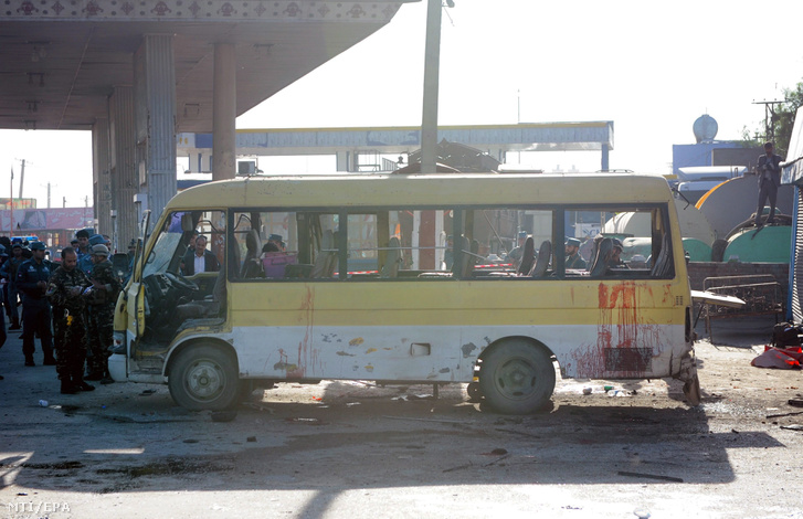 Rendőrök vizsgálják a kormányzati alkalmazottakat szállító buszt amelybe egy robbanószerrel megrakott gépkocsi hajtott Kabulban 2016. június 20-án.