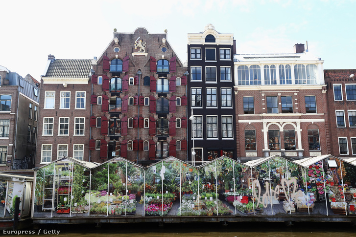 A Singel-csatornán úszó virágpiac és a csatorna menti lakóházak Amszterdamban
