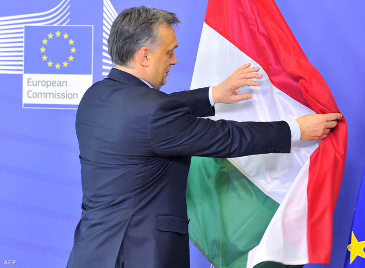 Orbán Viktor a magyar zászlót igazgatja egy brüsszeli találkozó helyszínén (2013.)
