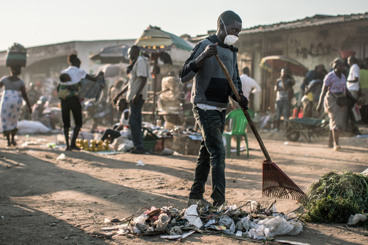 Szemetet seper az utcán egy angolai fiú az egyik járvány-sújtotta területen. Az utcára dobott hulladék ideális költőhely például a sárgalázat terjesztő szúnyogok számára.