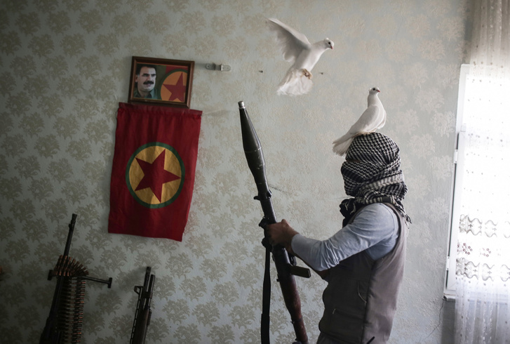 A Kurd Munkáspárt ifjúsági tagozatának egyik tagja pózol fegyverekkel az otthonában.