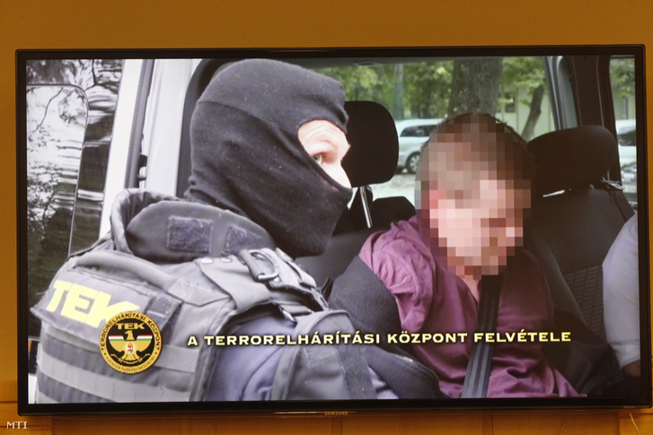 A férfi elfogásakor készült felvételt mutatják be egy tv-n a rendőrség sajtótájékoztatóján.