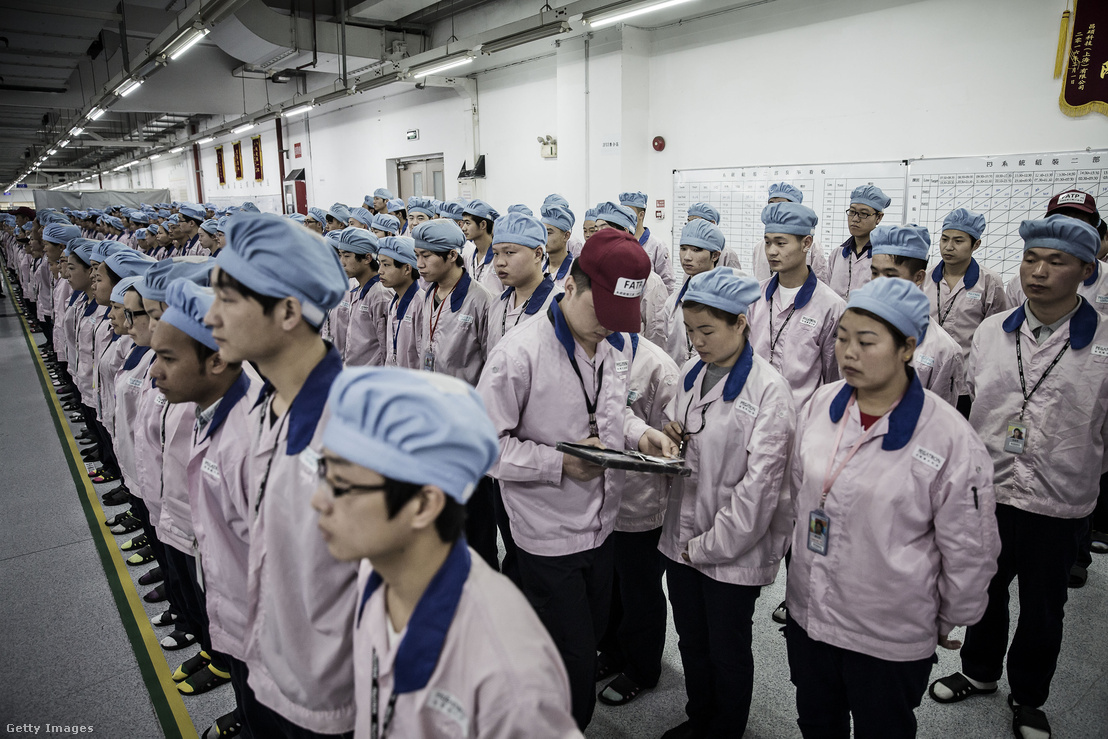 Ipadről ellenőrzi egy munkavezető a dolgozók kártyáit egy műszak előtt az Apple egyik kínai partnerének gyárában.