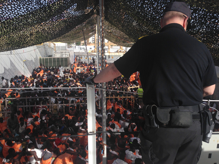 Menekültek várakoznak egy mentőhajón a palermói kikötőben
