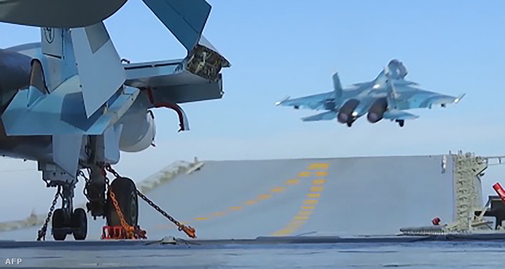 Képkocka az orosz védelmi minisztérium nyilvános videójából, amin a Földközi-tengeren állomásozó Kuznyecov repülőgép-hordozó látható. A minisztérium szerint a szíriai orosz légicsapásokban a repülőgép-hordozó is szerepet kapott.