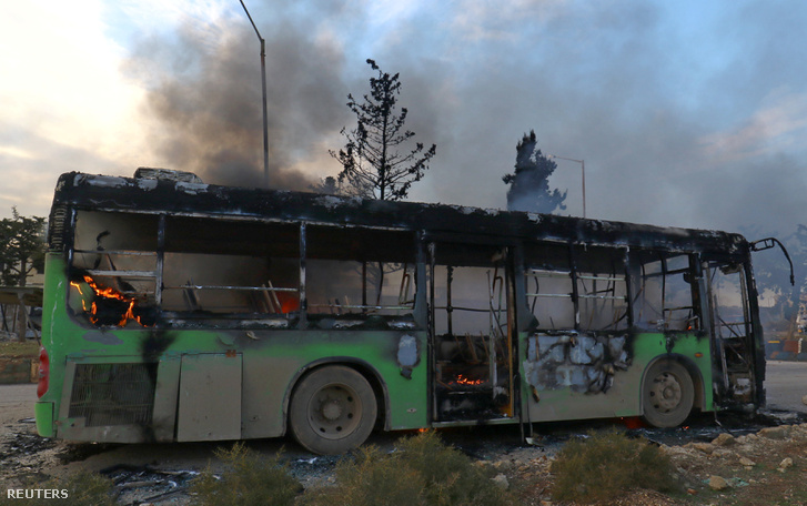 Egy támadás során felgyújtott és kiégett busz Aleppo közelében