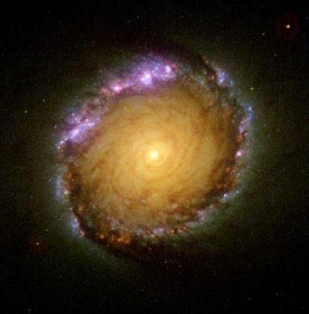 A centrumot gyűrű alakban körülölelő csillagkeletkezési terület egy spirális galaxisban. (NASA, ESA, D. Maoz, G.F. Benedict és tsai)