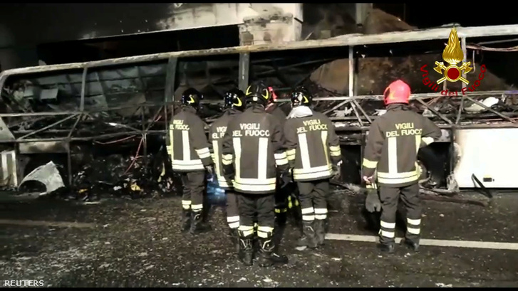 Tűzoltók dolgoznak a kiégett busz roncsainál
