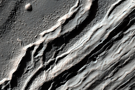 Egy, a Hellas-medence északnyugati részén lévő kráter falának szerkezete. A kutatók szerint egy idős kráterről van szó, melyet korábban folyékony láva, esetleg víz tölthetett ki, létrehozva a jelenleg megfigyelhető struktúrákat