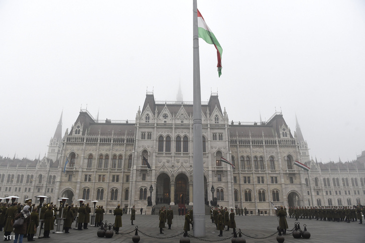 Katonai tiszteletadással felvonják, majd félárbócra eresztik a nemzeti lobogót a veronai buszbaleset áldozataiért elrendelt nemzeti gyásznapon az Országház előtti Kossuth Lajos téren 2017. január 23-án.