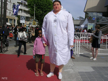 Pál Adrienn, a túlsúlyos ápolónő óriásfigurája egy kislánnyal a cannes-i Fesztiválpalota előtt