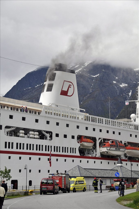 Az MS Deutschland német luxushajóból füst gomolyog a norvégiai Eidfjorden kikötőjében