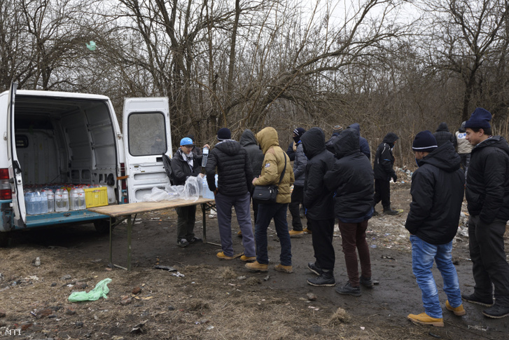 Osztrák önkéntesek vizet osztanak menekülteknek a vajdasági Szabadka külterületén az újvidéki vasútvonal közelében 2017. február 21-én.