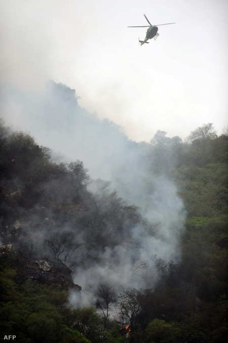 A gép füstölgő roncsai a hegyoldalban