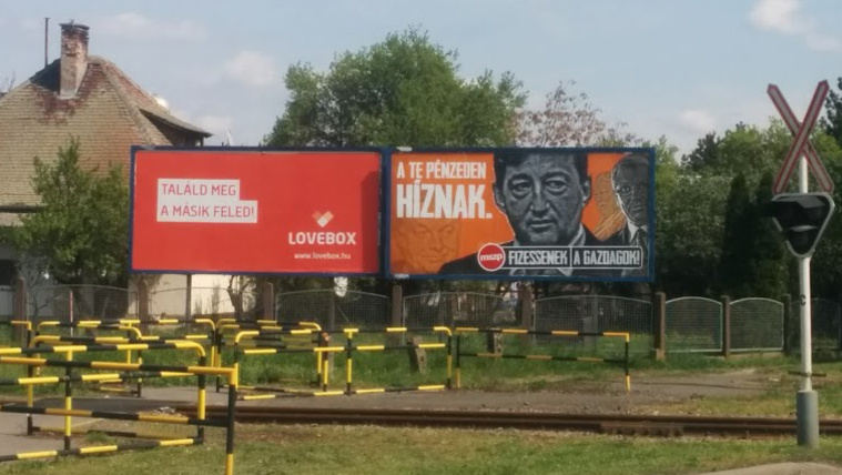 Lovebox és fideszező plakátok egymás mellett Szarvas határában