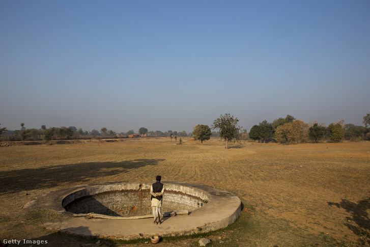 Farmer áll egy vízgyűjtő kút szélén, a kiszáradt földjén, Patharkhera falu mellett.