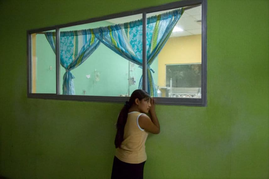
                        	A fotón a 14 éves Rosario figyeli a San Benito Klinika újszülött intenzív osztályának ablakán keresztül kisbabáját.