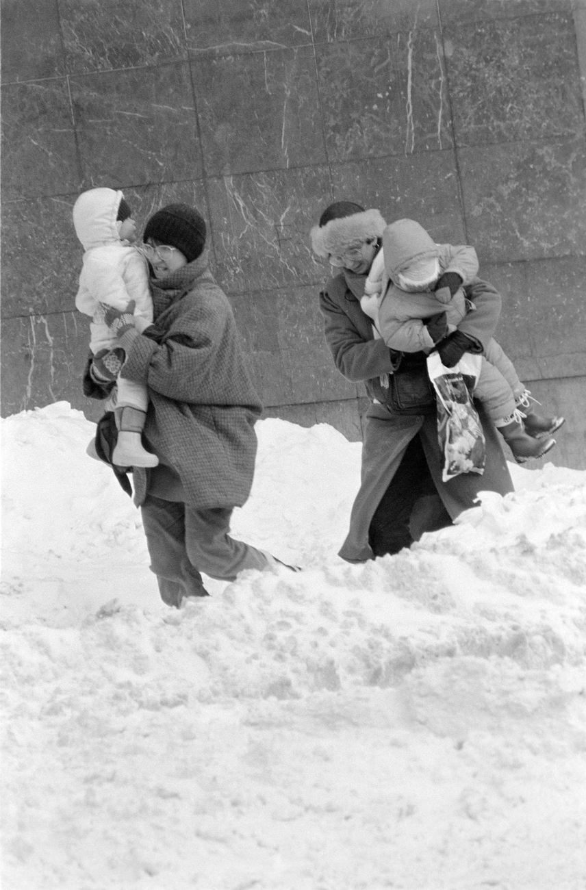 
                        	Nők gyermekeiket fölemelve haladnak a csúszós, 30-50 centiméteres hóval betakart járdán a fővárosban 1987. január 12-én.