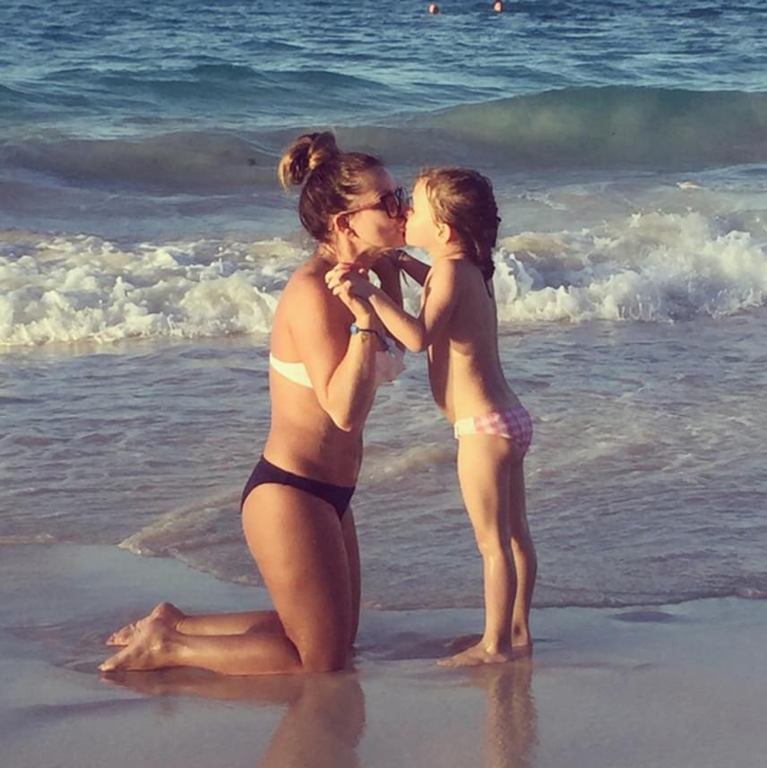 	Judy és kislánya, Maja kezüket összekulcsolva puszizkodik a tengerparton. A Groovehouse egykori énekesnője nagyon dögösen néz ki bikiniben.