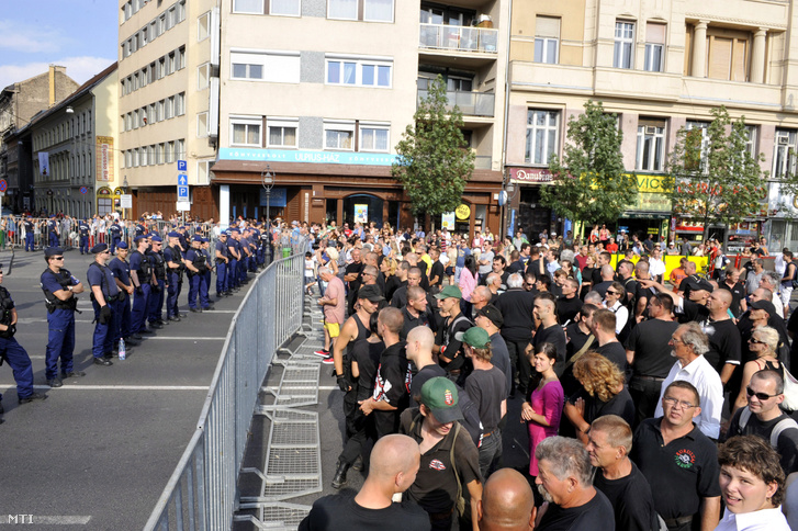 Az Új Magyar Gárda Bajtársiasság napján tartott megemlékezésének sötét ruhába átöltözött résztvevői állnak a 18. Budapest Pride közelében az Erzsébet téren 2013. július 6-án.