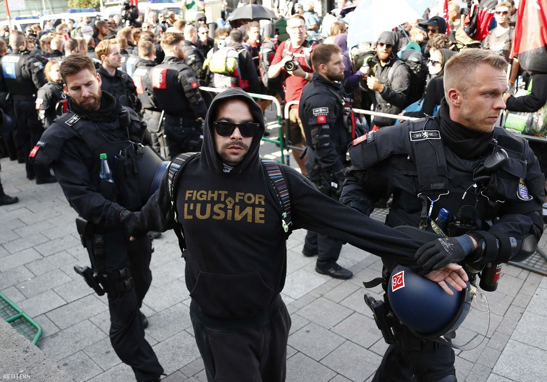 Egy tüntetőt állítanak elő rendőrök a hamburgi pályaudvar közelében, nem sokkal azután, hogy leszállt a vonatról