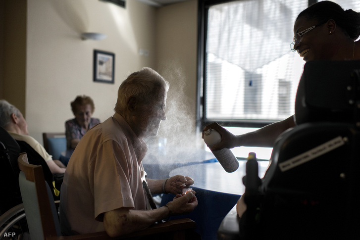 Nővér fúj vízpermetet egy idős férfi arcára a hőségben egy lyoni öregek otthonában, Franciaországban 2017. augusztus 5-én