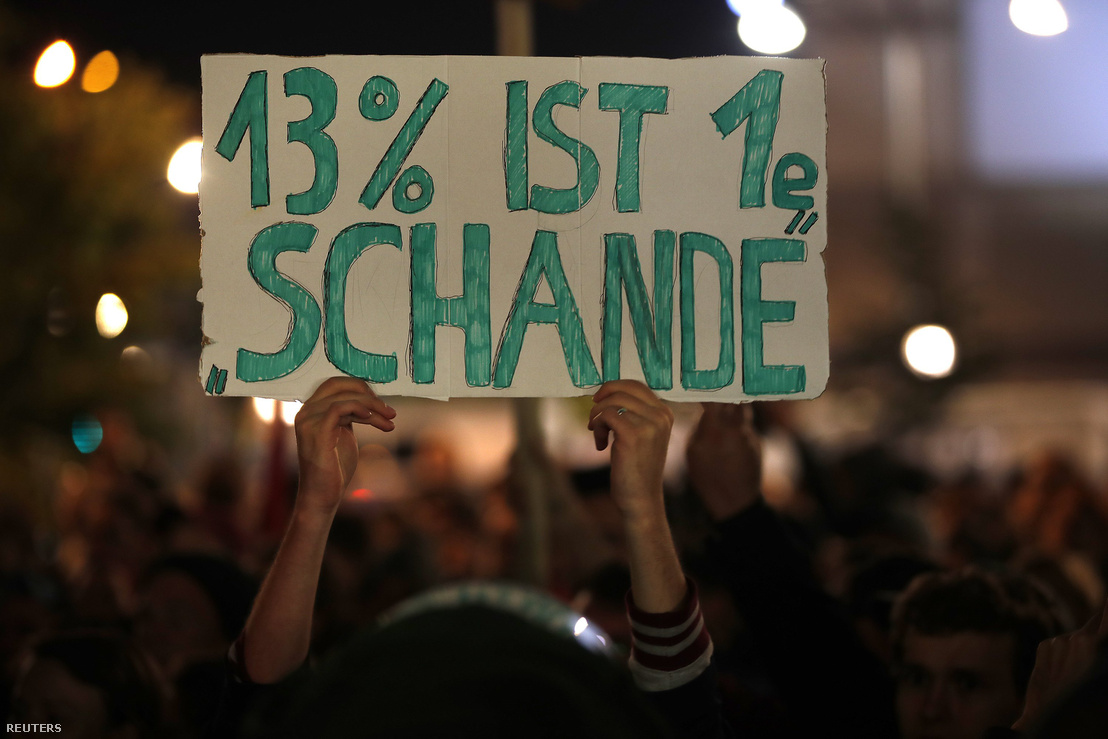 "Szégyen a 13 százalék" – olvasható egy tüntető tábláján vasárnap este, Berlinben