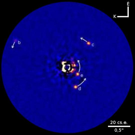 A HR 8799 négy bolygója. A "b", "c" és "d" jelűeket még 2008-ban detektálták, az "e" jelű pedig az új felfedezés. A nyilak a planéták következő 10 évre előrejelzett elmozdulását jelzik, amint keringenek a csillaguk körül. A felvétel a hawaii Keck II teleszkóp koronagráfjával készült.