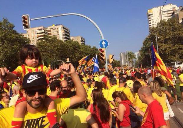 Piqué itt épp a fiával tüntet a függetlenségi szavazásért a Katalónia függetlenségét jelképező piros-sárga sávos katalán nemzeti színekben