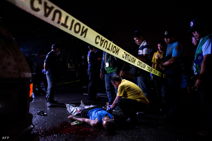 Rendőrök helyszínelnek egy kábítószer ellenes akcióban lelőtt férfi holtteste mellett Manilában 2017. május 18-án